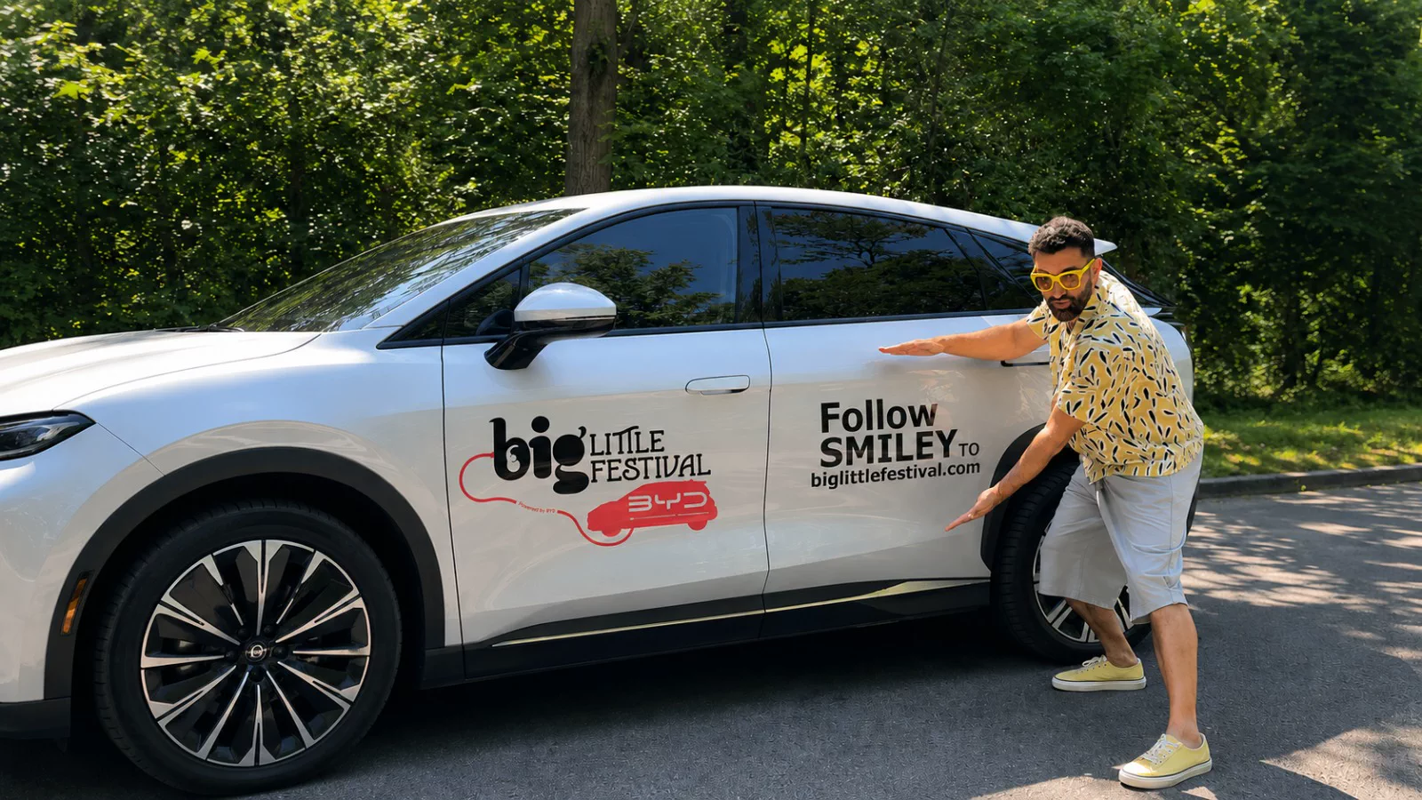 Smiley lângă un automobil BYD inscripționat cu identitatea Big Little Festival.